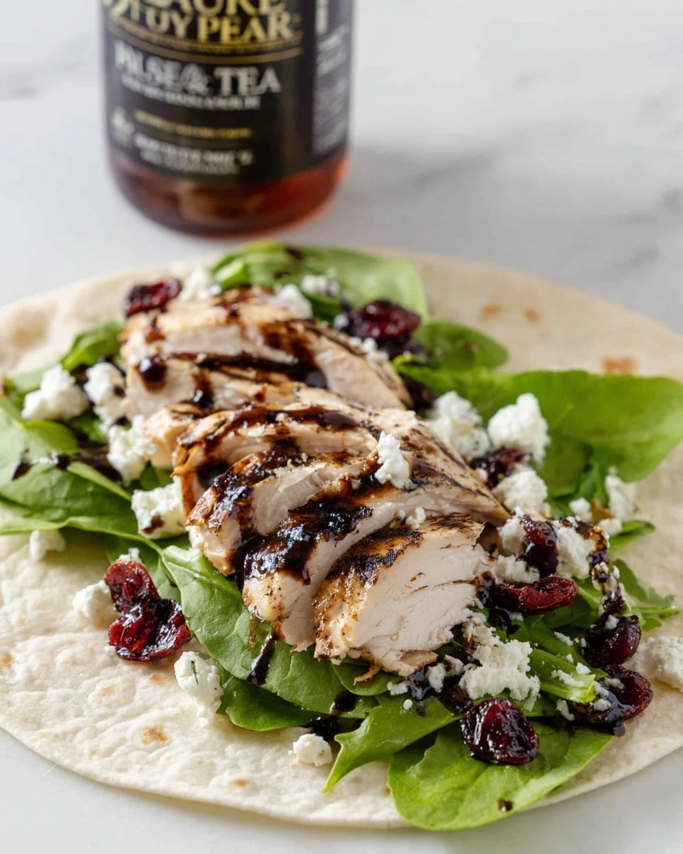 A white tortilla wrap is laid flat on a white marbled surface, layered with fresh green arugula at the bottom, topped with several slices of grilled chicken breast that have dark grill marks and are drizzled with a dark balsamic glaze. Over the chicken and greens, there are scattered white crumbles of goat cheese and dried deep red cranberries, with some chopped nuts sprinkled on top for texture. In the background, a bottle of Pure Leaf Raspberry iced tea is visible. photo taken with an iphone --ar 4:5 --v 7